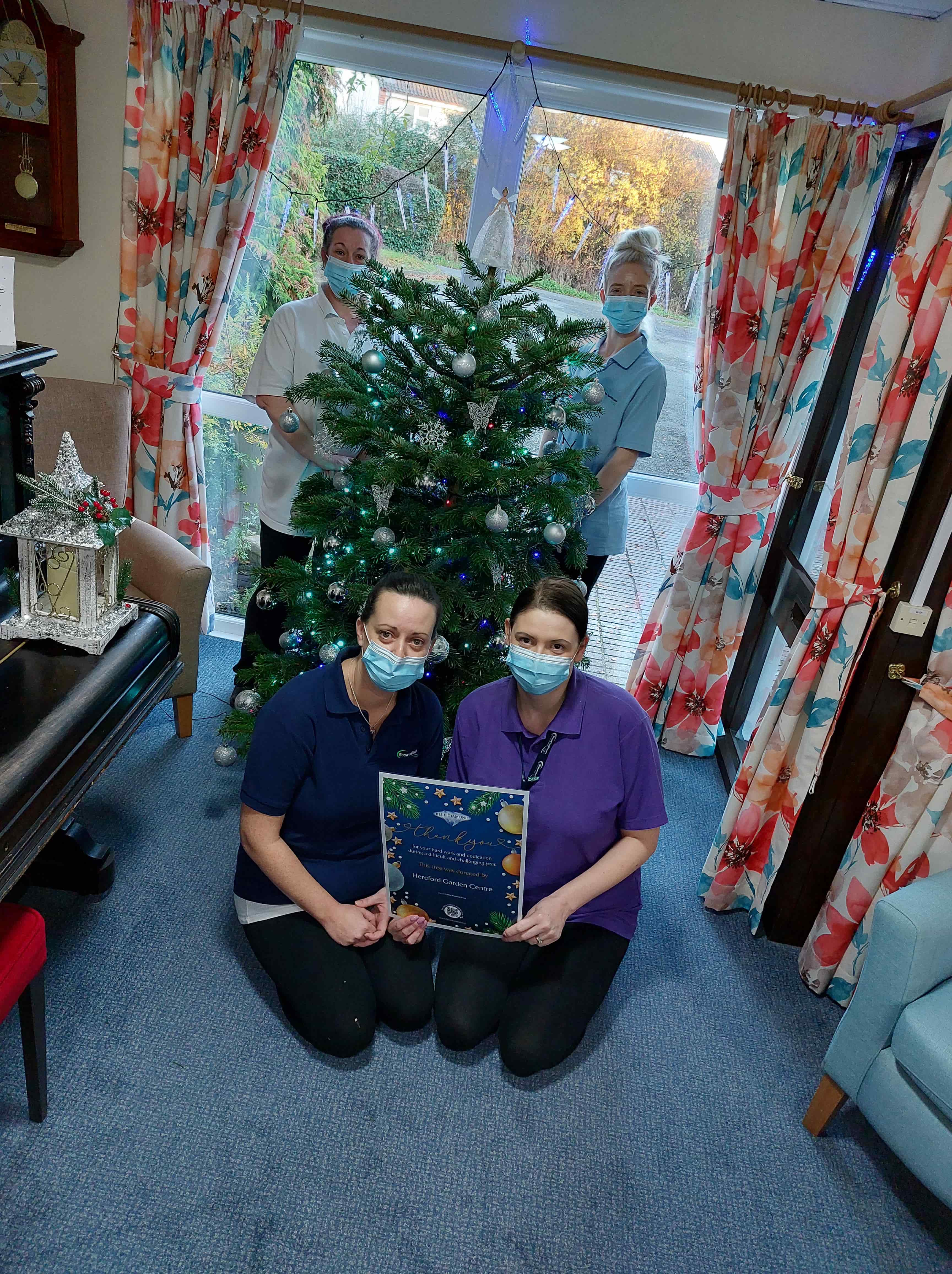 employees sitting by the Christmas tree