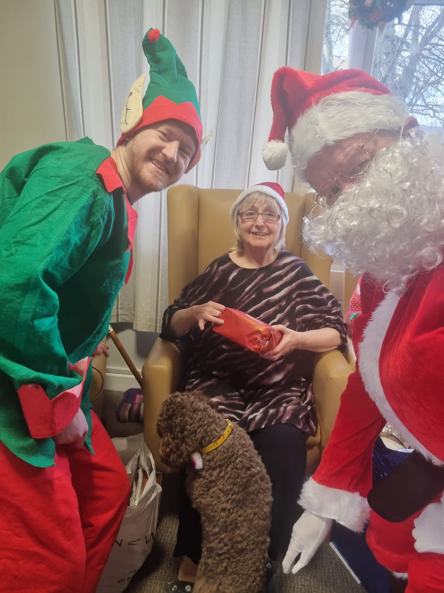 resident receiving gift of Santa and his helpers